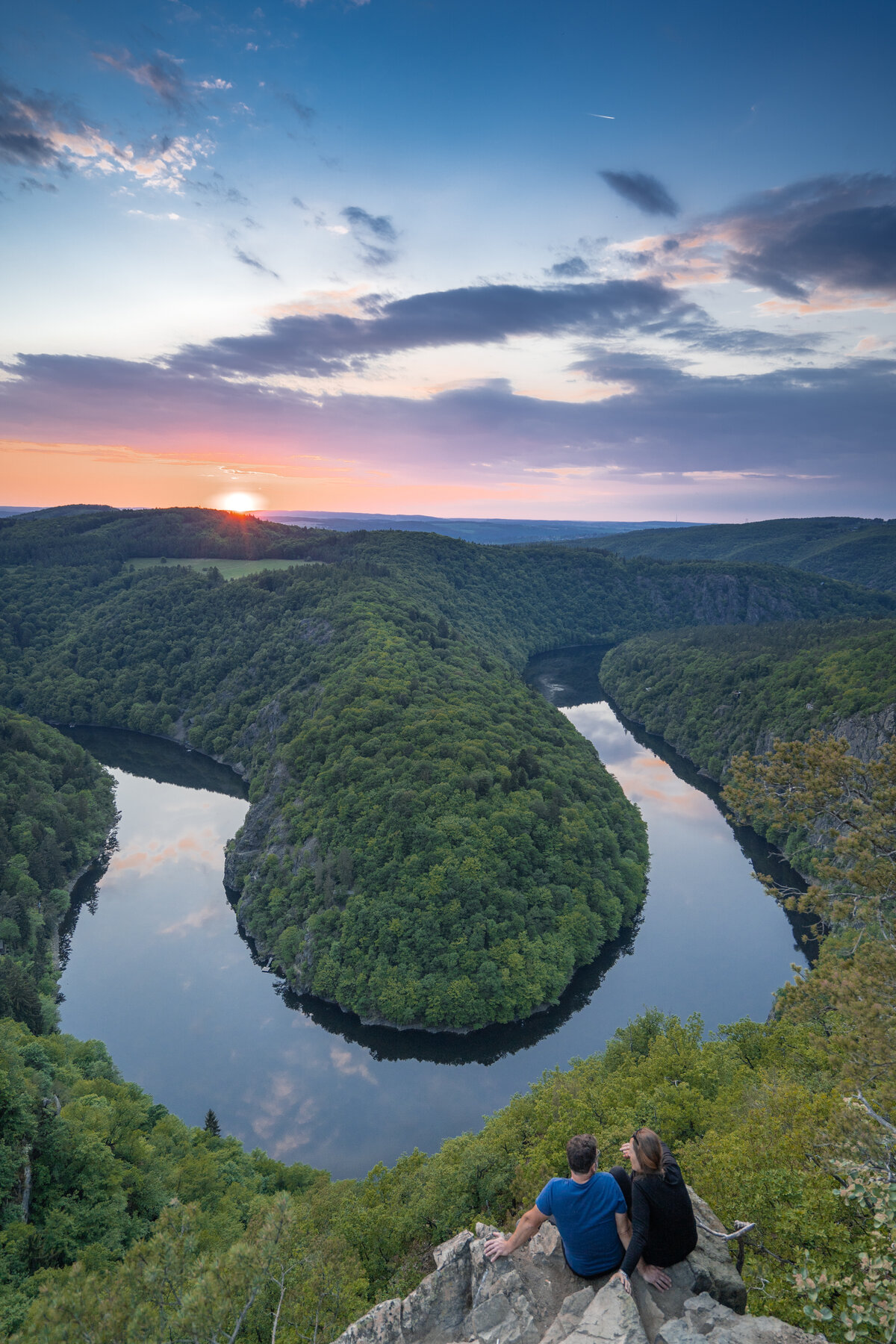Couple at Viewpoint Máj enjoying the Czech Horseshoe Bend at sunset
